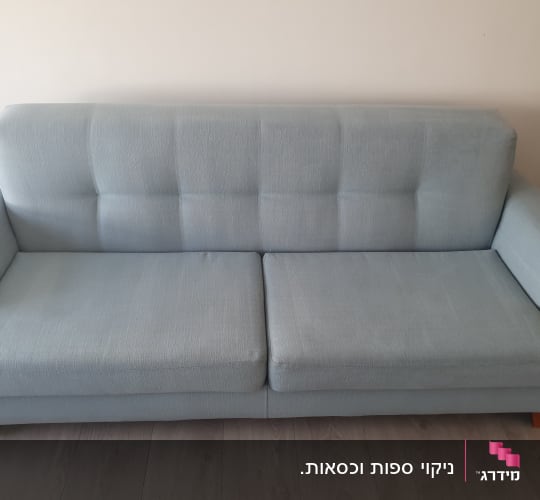 ספה כחולה עם ריפוד בד על רצפת עץ